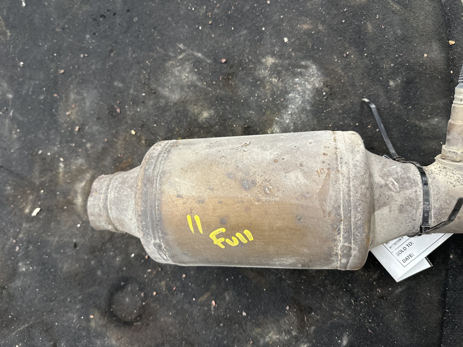 Scrap catalytic converter on the SMASH inspection floor, tagged and marked full